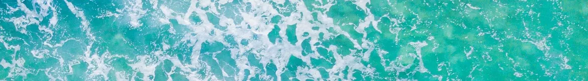 Aerial view of turquoise ocean waves with white foam patterns creating a vibrant and dynamic seascape.