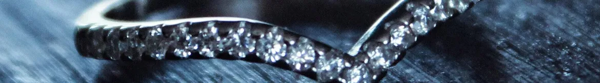 A close-up of a sparkling diamond ring set against a dark textured background, exuding elegance and luxury.