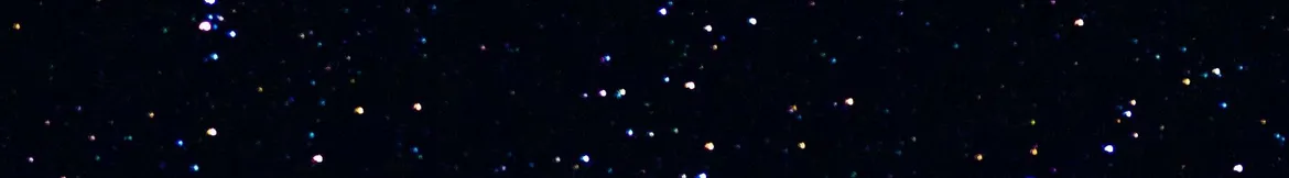 A starry night sky filled with colourful, shimmering specks of light against a deep black background.