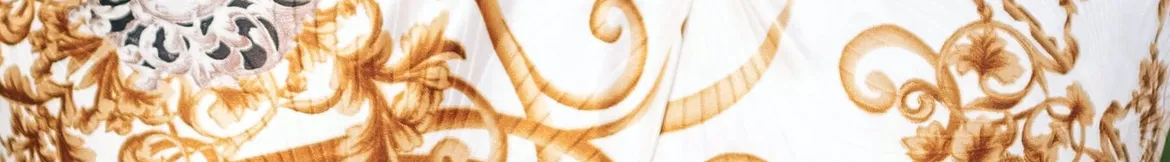 Elegant golden baroque-style patterns on a white fabric, showcasing intricate and luxurious decorative details.